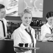 Confident waitress serving coffee with tray